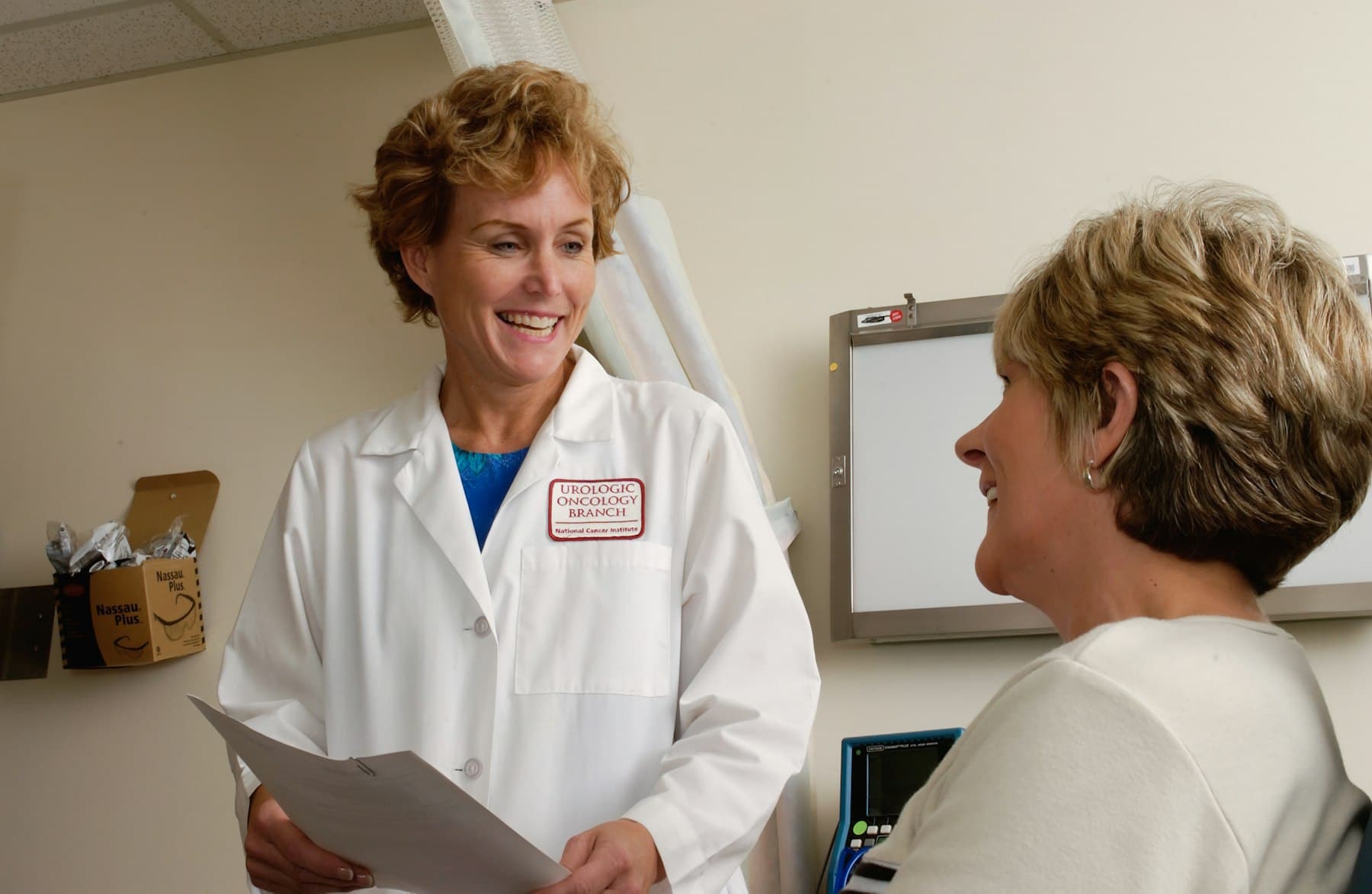A clinician reviewing a patient's blood results at a clinic desk